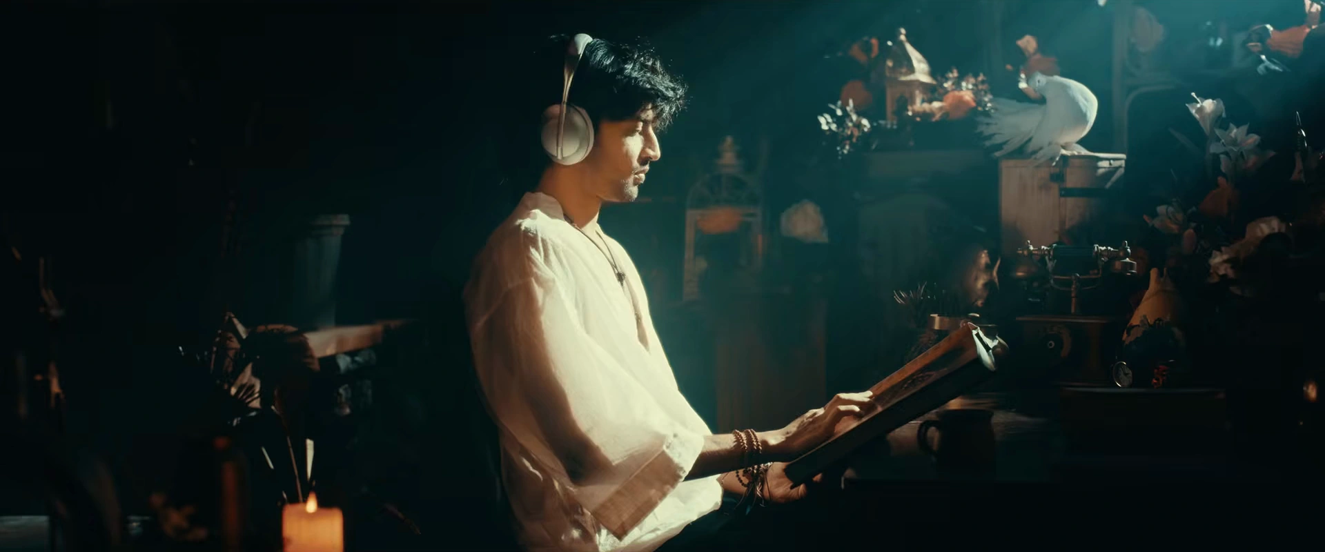 Vivasvaan with headphones and a book in an ornate room